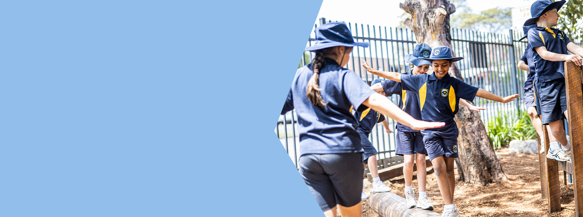 Student balancing on a log in the playground at Students learning together in the classroom with their teacher at St Mary's Primary School Rydalmere