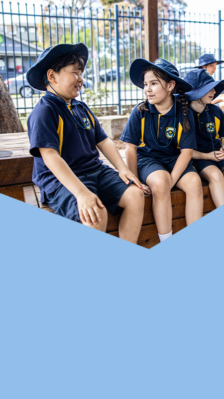 Students sitting together in the playground at St Mary's Primary School Rydalmere