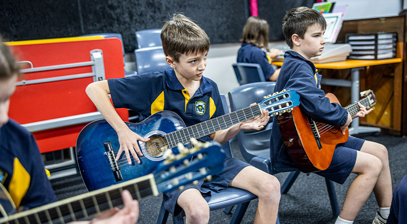 Students learning to play the guitar at St Mary's Primary School Rydalmere