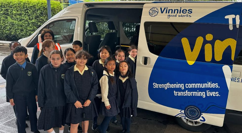 Students standing in front of the Mini Vinnies van at St Mary's Primary School Rydalmere