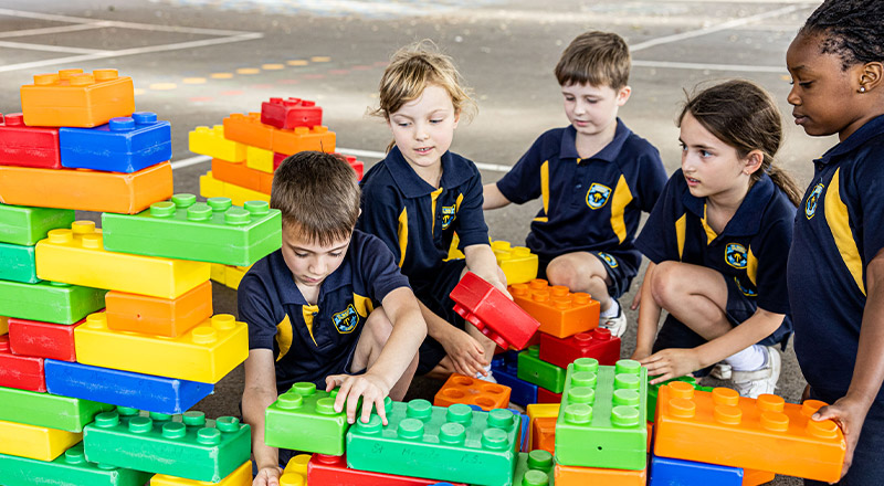 Students building with giant blocks in the playground at St Mary's Primary School Rydalmere