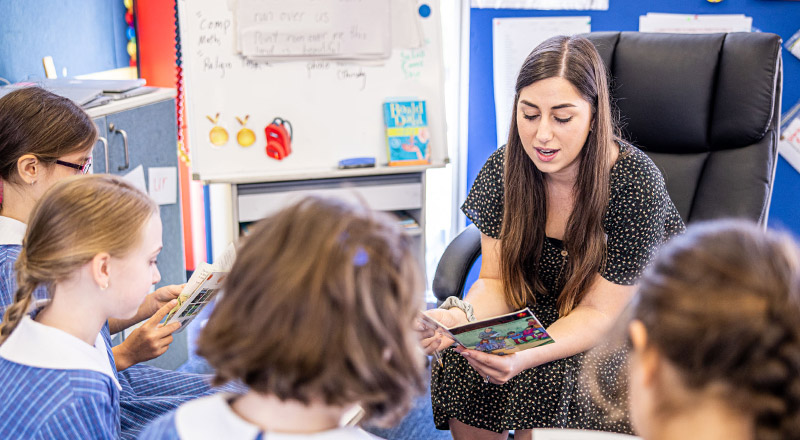 Students learning to read in the classroom with their teacher at St Mary's Primary School Rydalmere