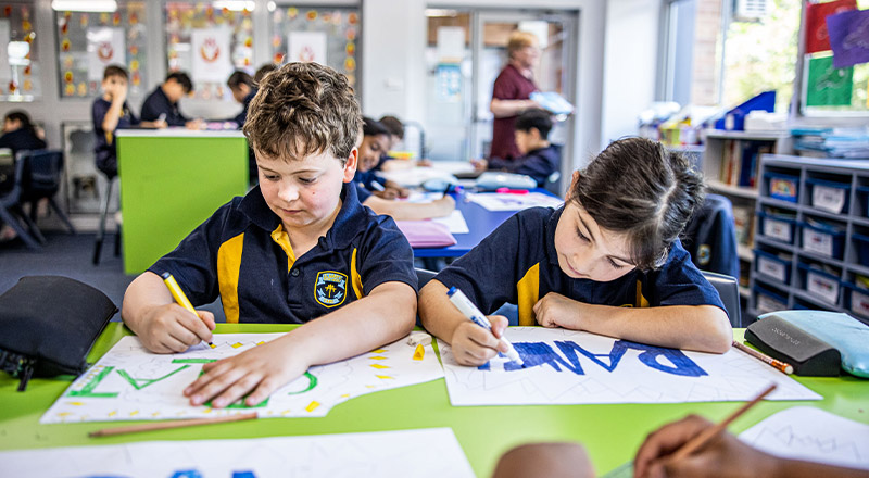 Students painting in the classroom at St Mary's Primary School Rydalmere