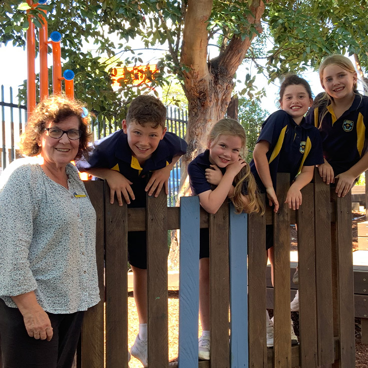 Defence School Mentor Dianne Woods with students in the playground at St Mary's Primary School Rydalmere