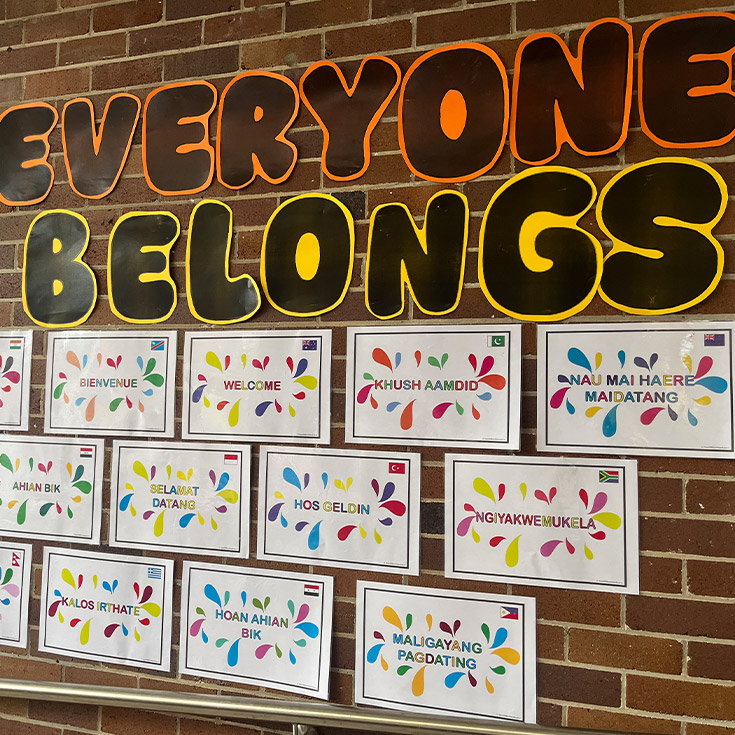 Student artworks hanging on the all under the sign reading Everyone Belongs at St Mary's Primary School Rydalmere