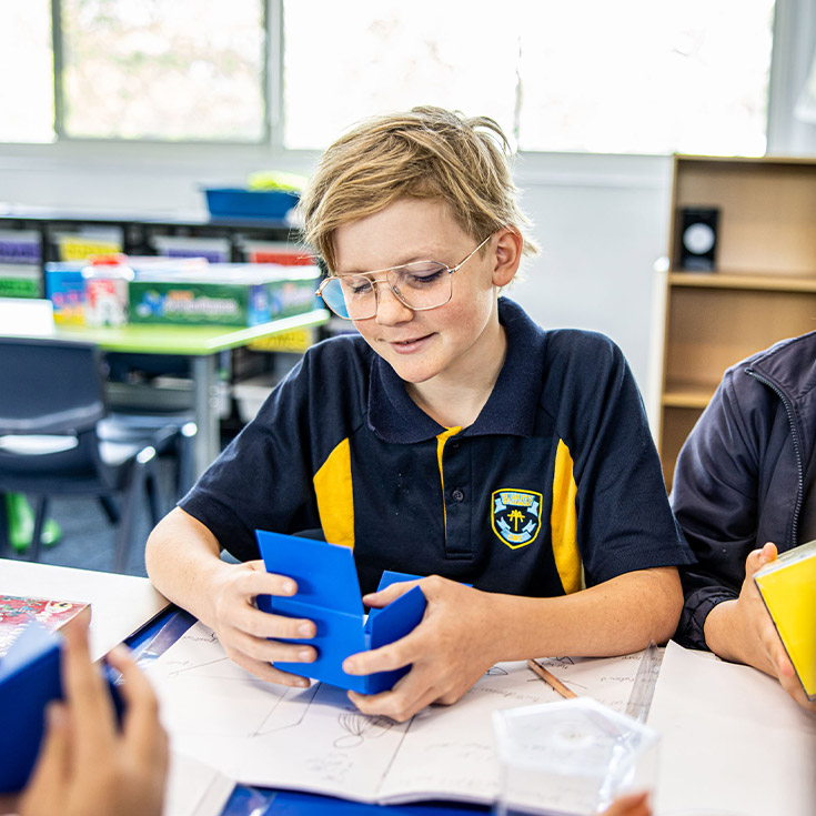 Student holding a prism in the classroom at St Mary's Primary School Rydalmere