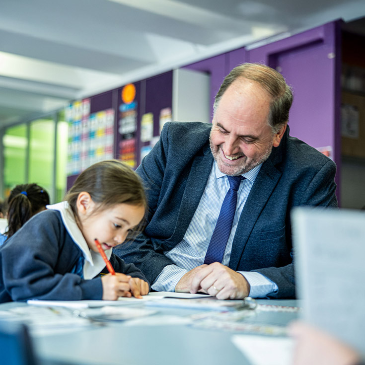 Principal Richard Blissenden looking at a globe with studets in the classroom at St Mary's Primary School Rydalmere